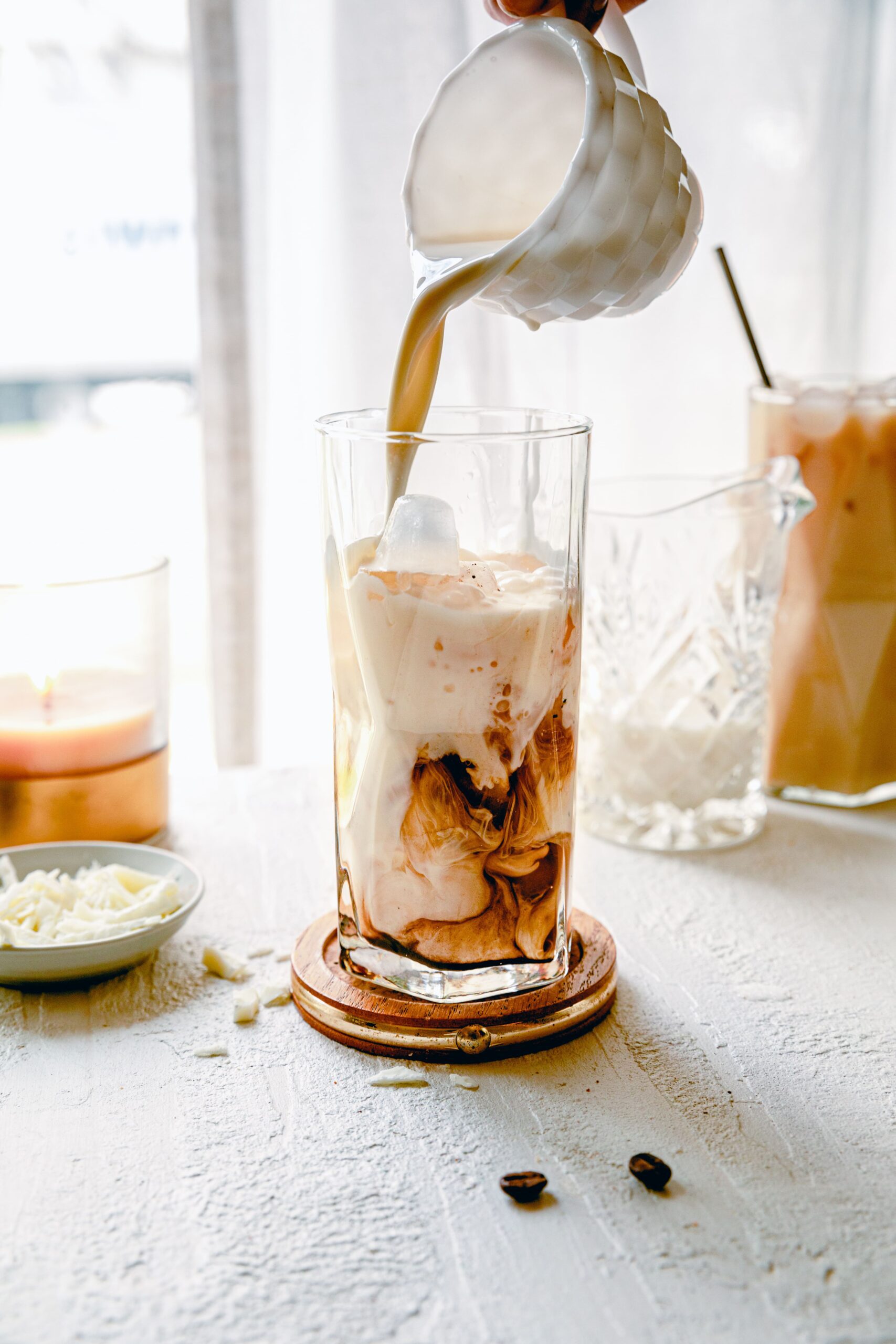 pouring milk into an iced espresso
