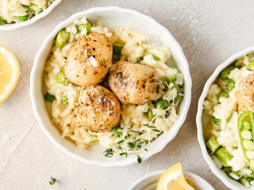 white bowls of risotto and blackened scallops