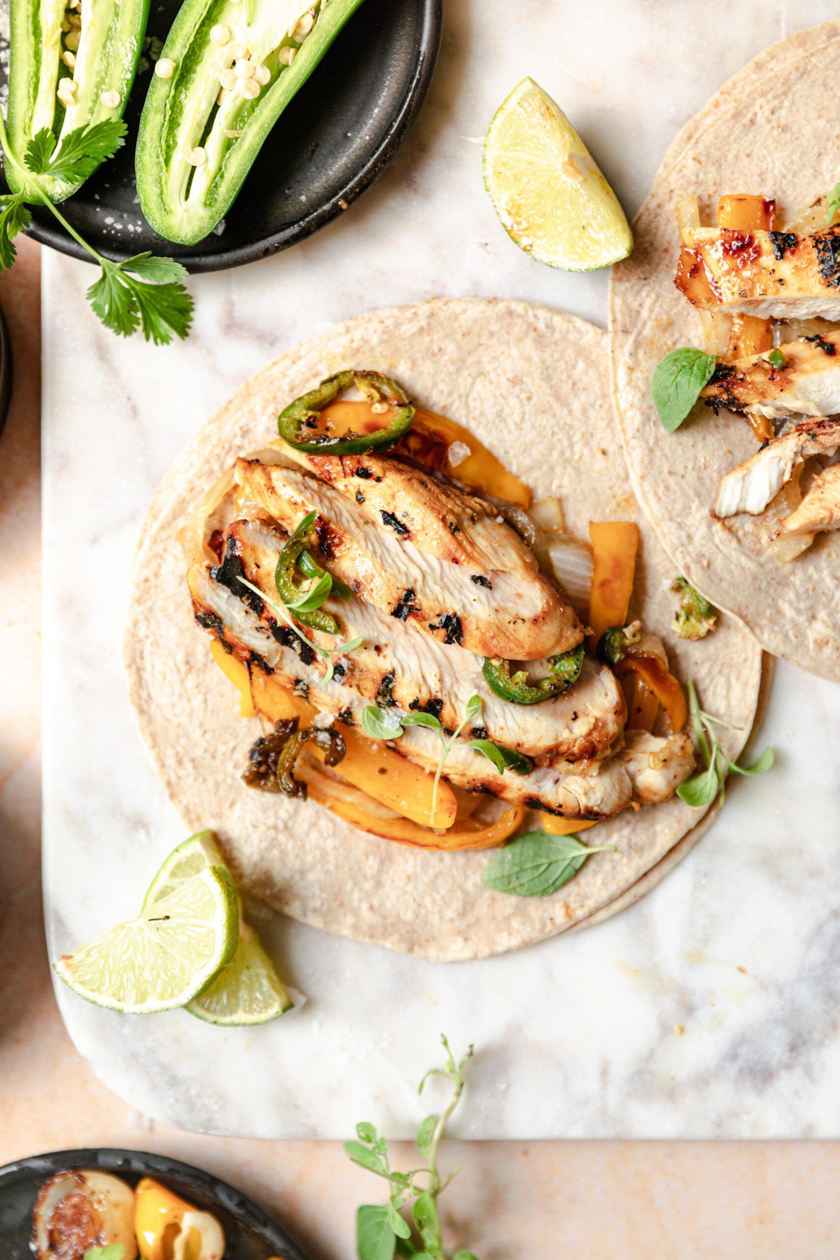 grilled chicken on a tortilla with peppers and onions