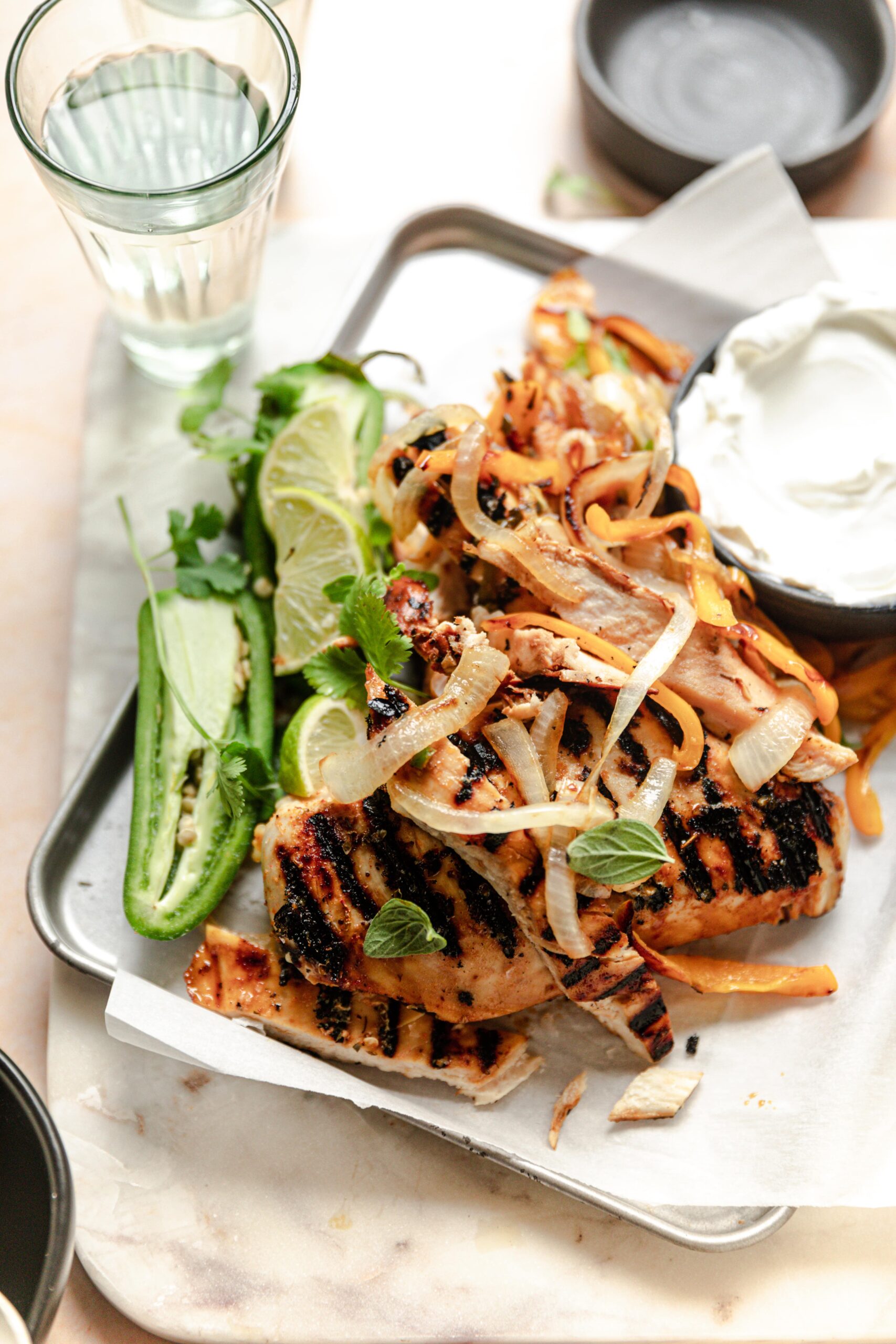 grilled fajitas on a sheet tray with jalapeno garnish