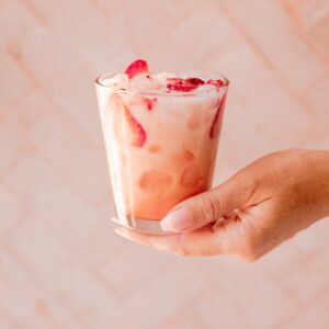 hand holding starbucks pink drink on pink backdrop