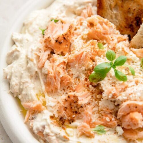 close up of cream cheese salmon dip with a basil garnish