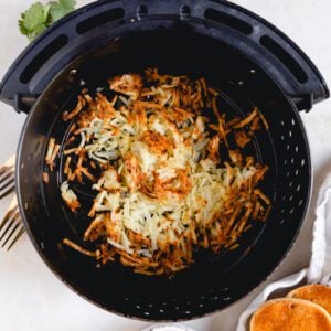 air fryer basket full of crispy hashbrowns