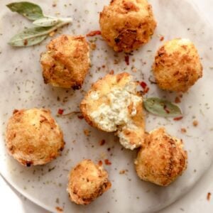 overhead photo of plate of goat cheese ball, one broken in half