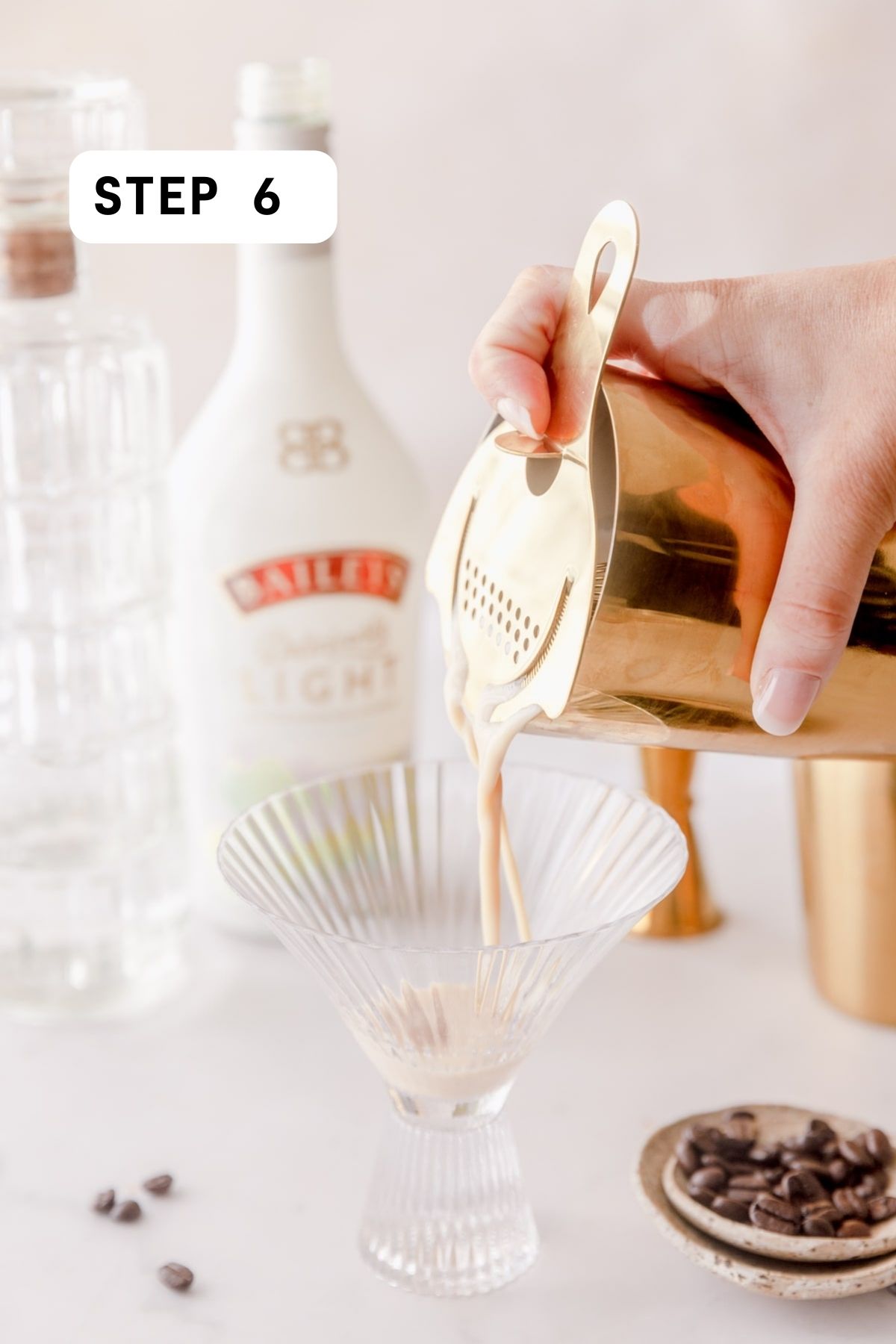 Pouring espresso martini into a glass. 