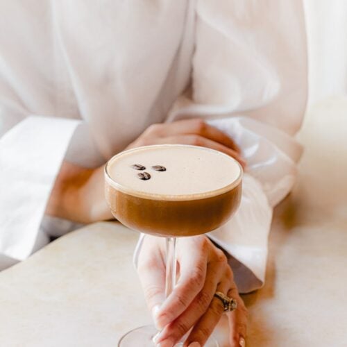 woman in white shirt holding an espresso martini