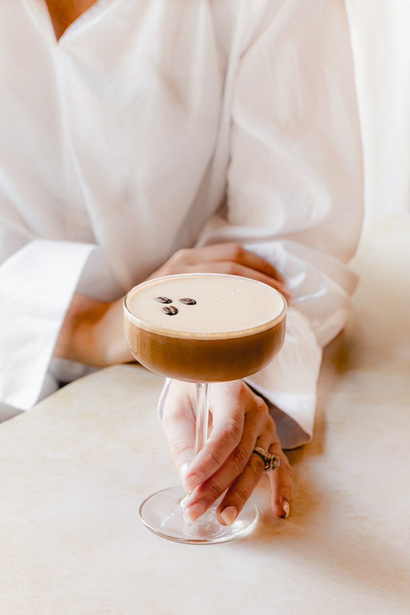 woman in white shirt holding an espresso martini