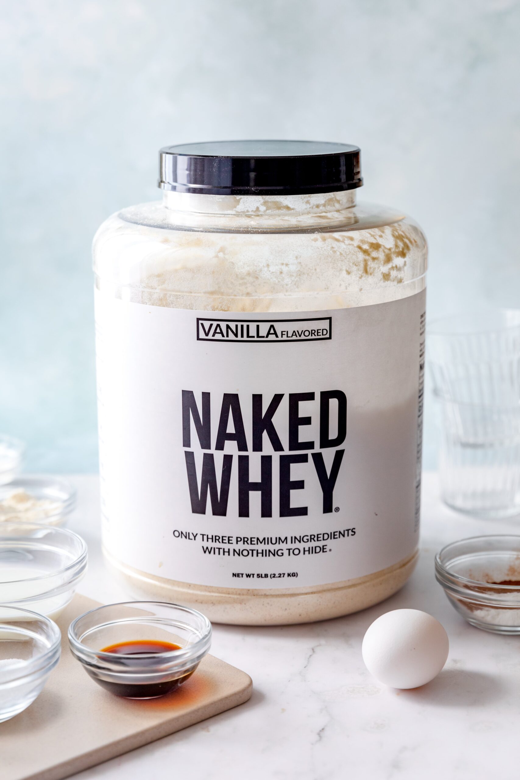 large container of Naked Nutrition vanilla whey protein powder