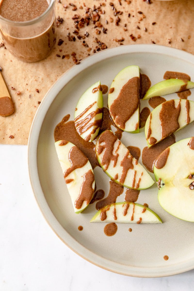 green apple with granola butter drizzled over it