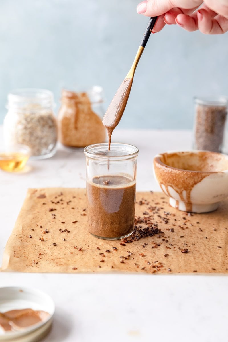 Granola butter in a mason jar with a knife dipping into it.