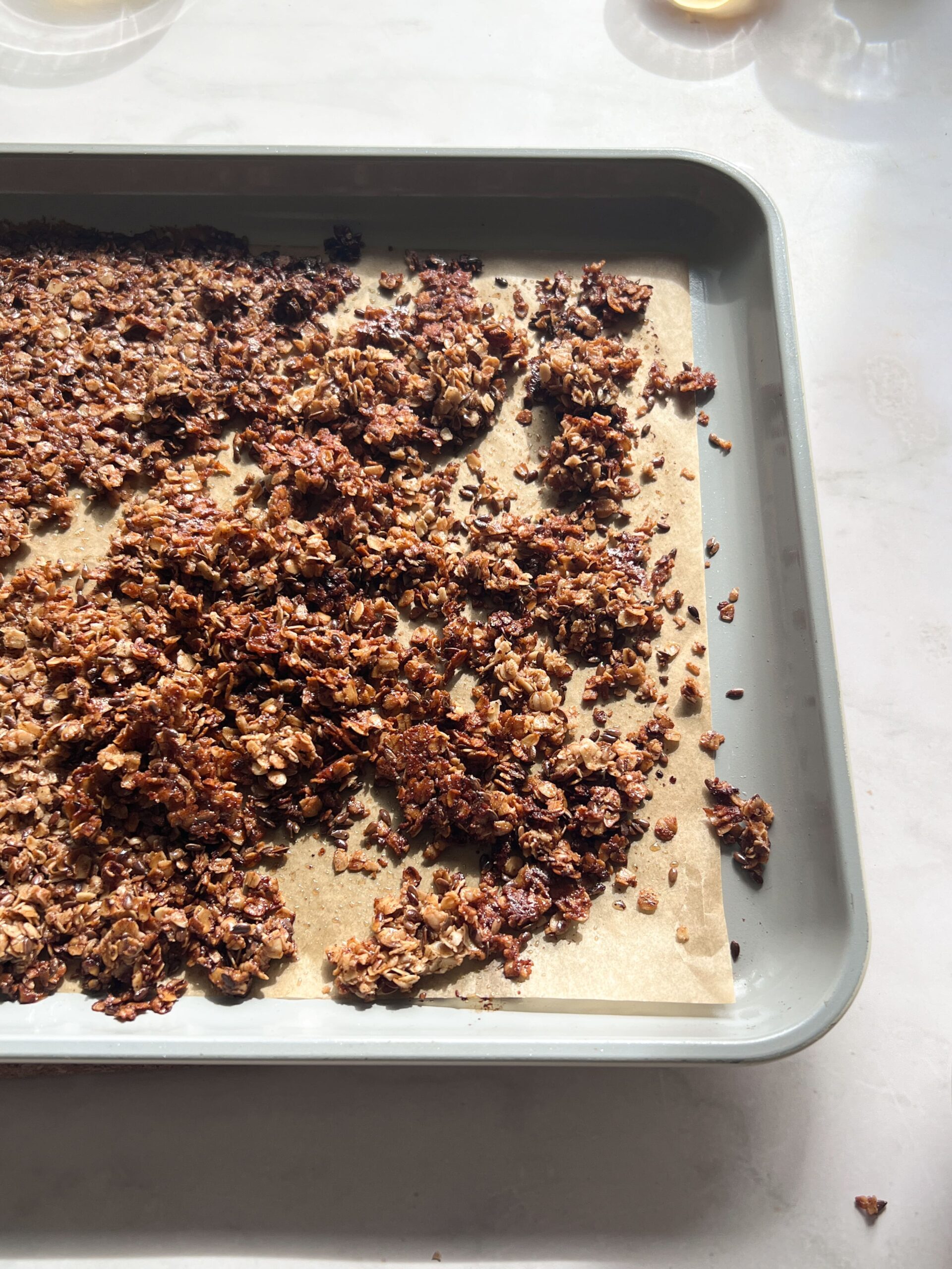 Crumbled homemade granola on a sheet tray.