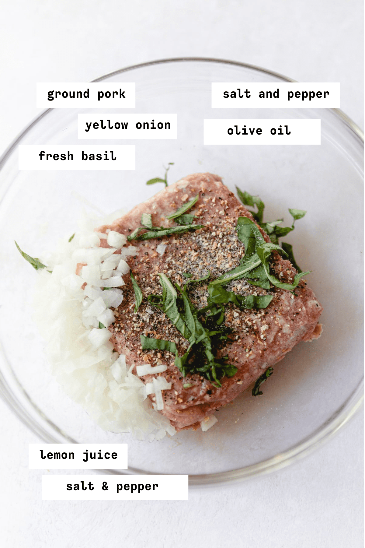 Greek meatball ingredients in a clear glass bowl
