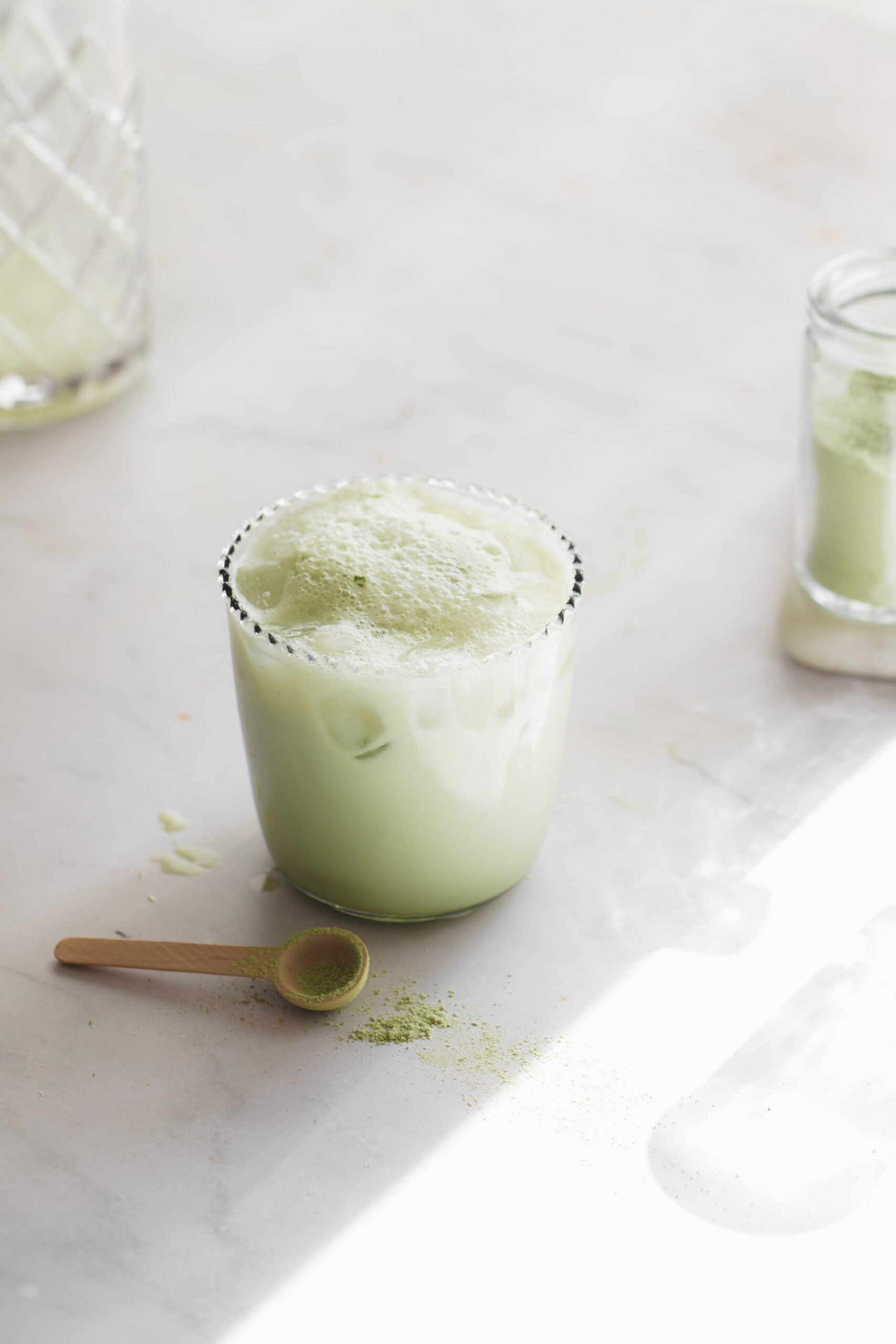 glass of matcha green tea latte with a matcha spoon