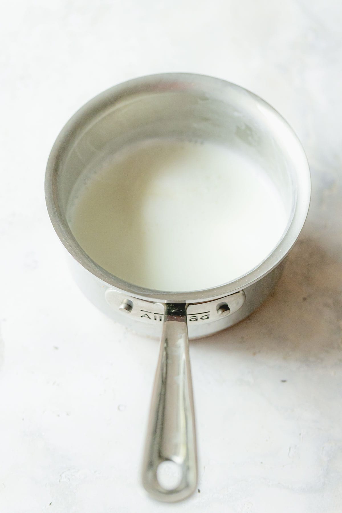 Steaming milk in a stainless steel saucepan. 