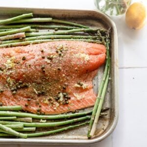 close up photo of raw salmon seasoned with lemon zest, capers, and dill
