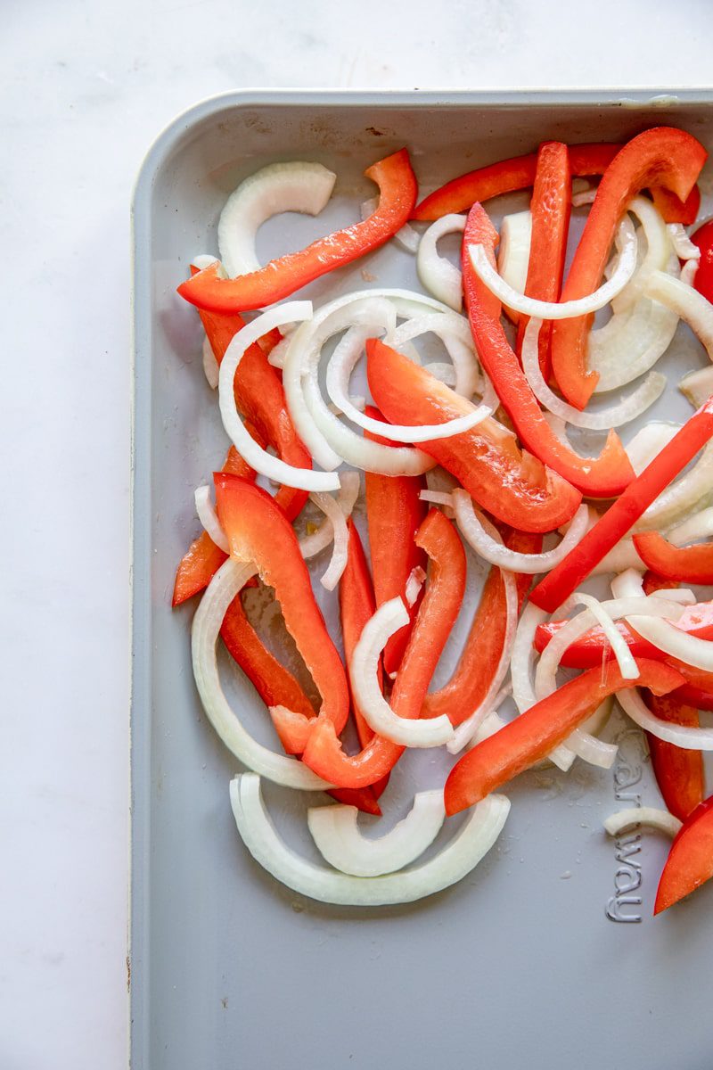 close up overhead photo of the sheet tray with sliced onions on it