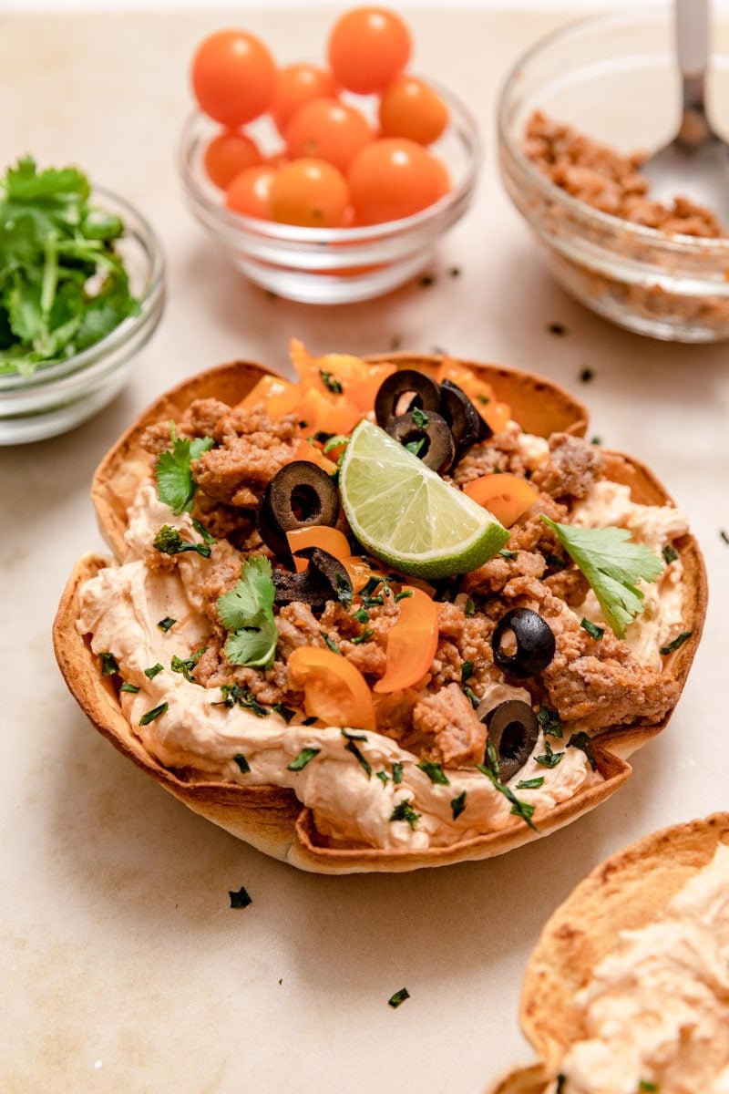 taco dip surrounded by toppings