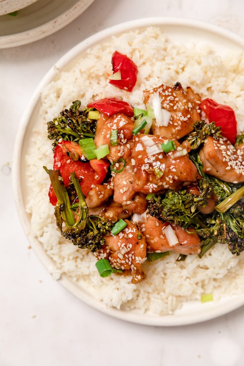bowl of white rice topped with chicken teriyaki and veggies