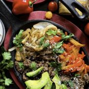 A platter of shaved beef fajitas with all the toppings.