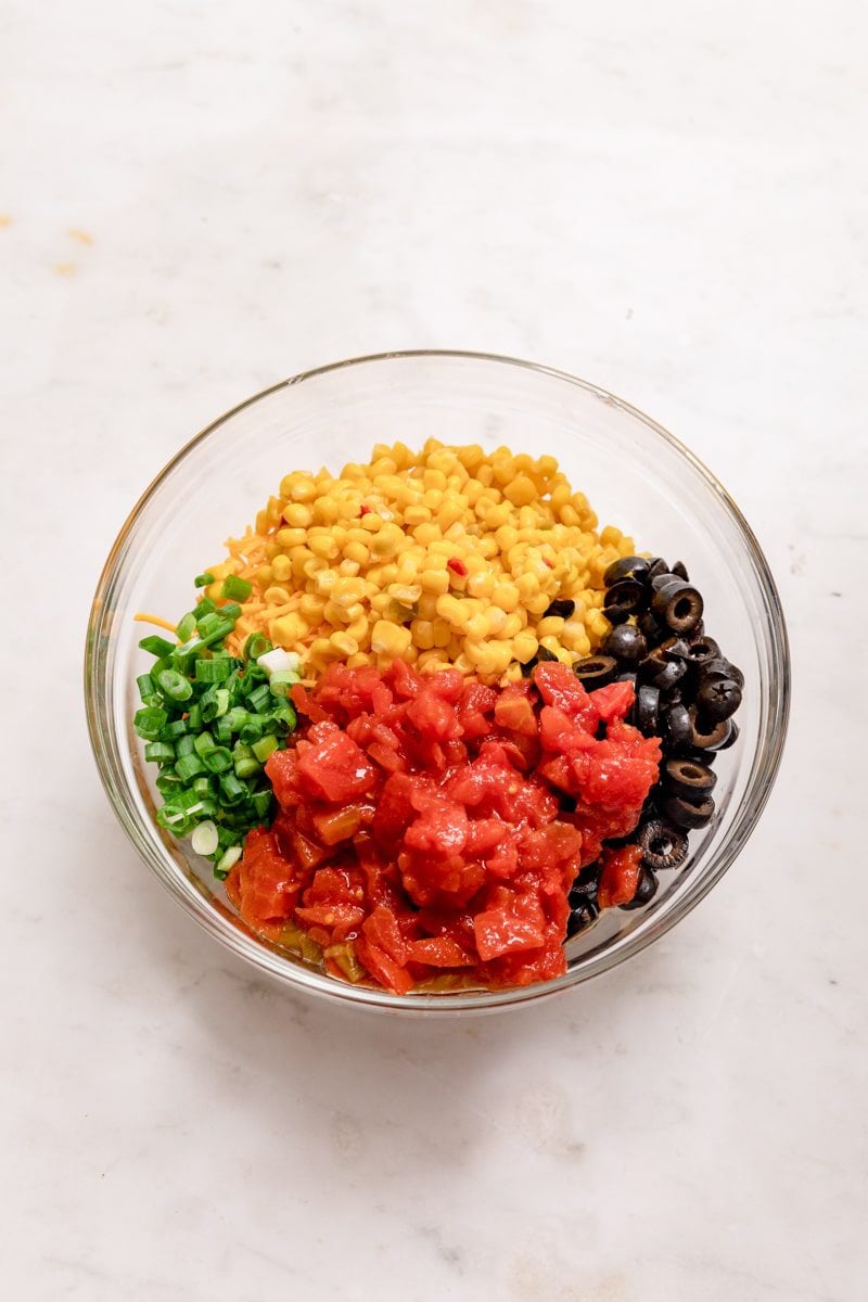 all Mexican corn dip ingredients in a glass mixing bowl