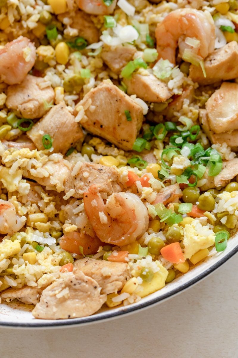 close up of shrimp and chicken stir fry in a white skillet 