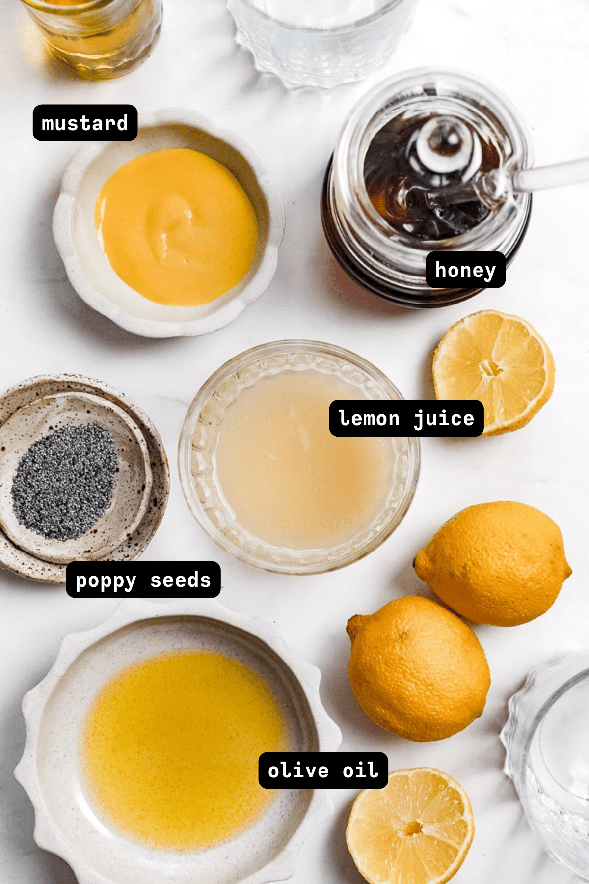 overhead photo of lemon poppy seed dressing ingredients in small bowls
