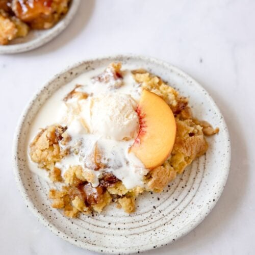 plated peach cobbler with cake mix and ice cream on top