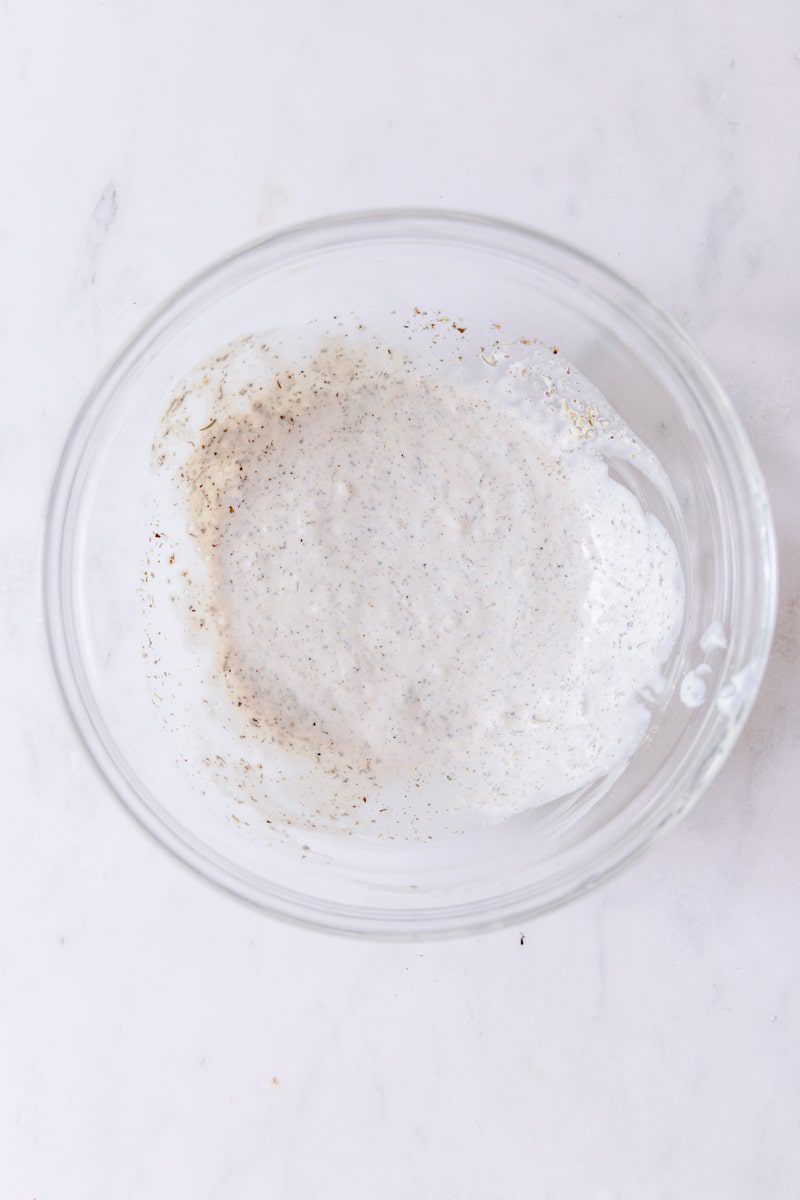 mixing together the dressing in a clear bowl