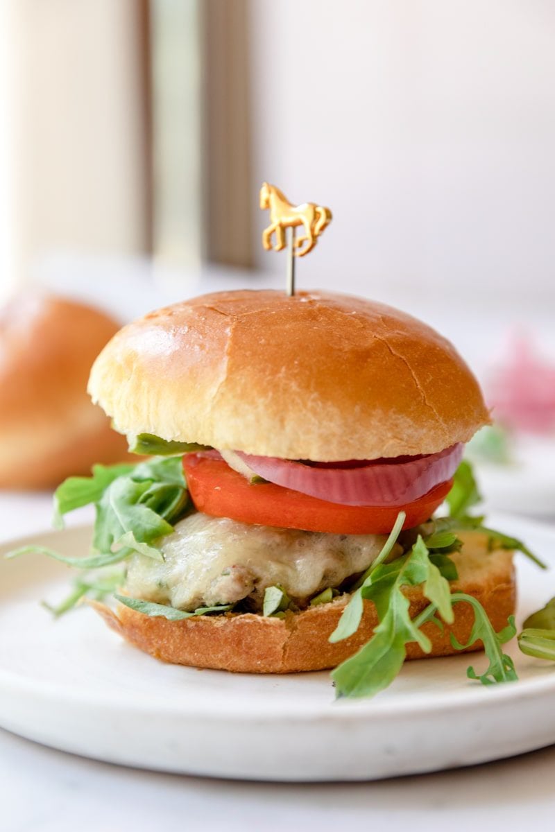 turkey burger on a white plate with a pick in it