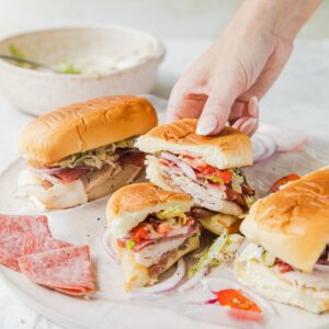 italian grinder sandwich cut in half being held by a hand