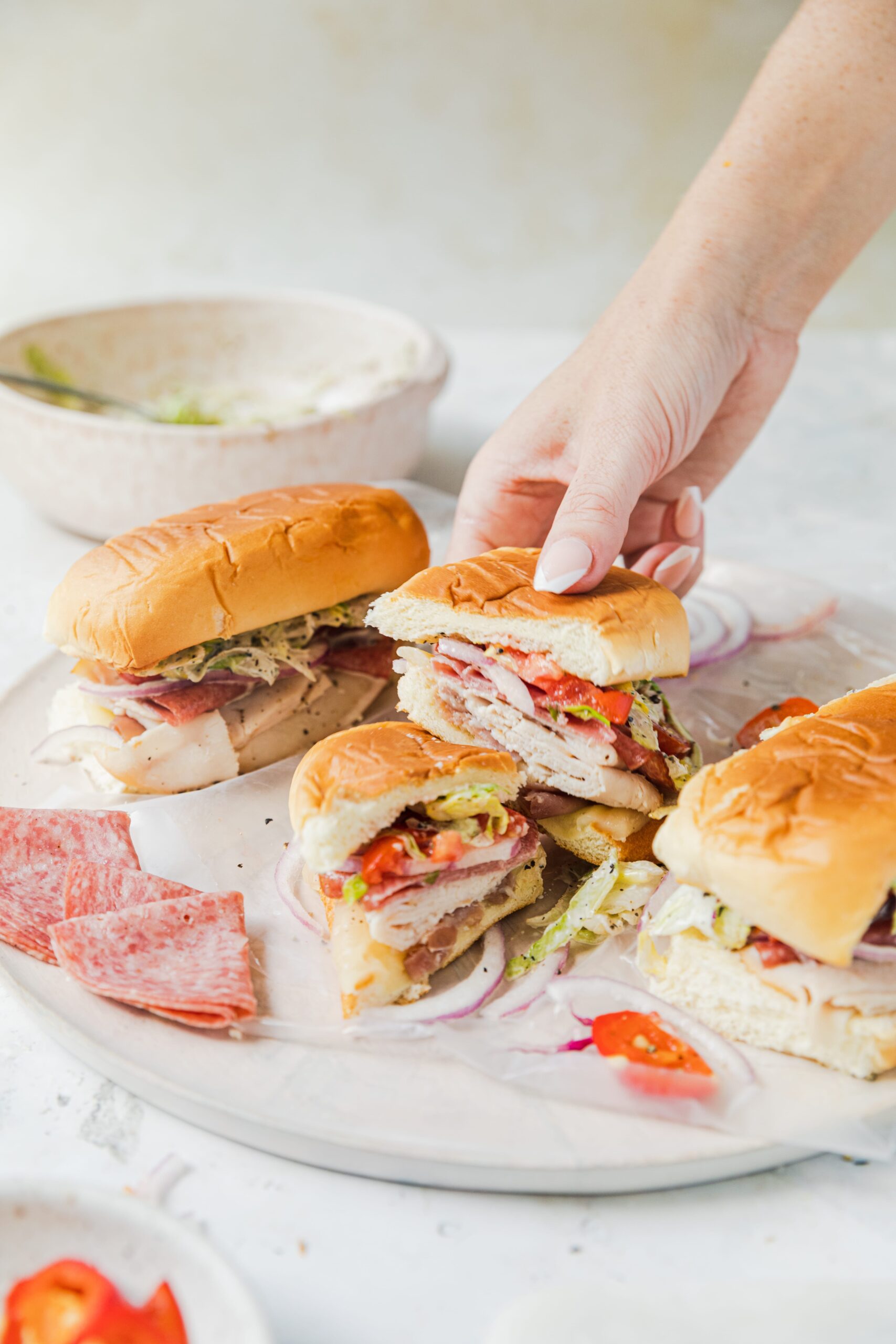 italian grinder sandwich cut in half being held by a hand