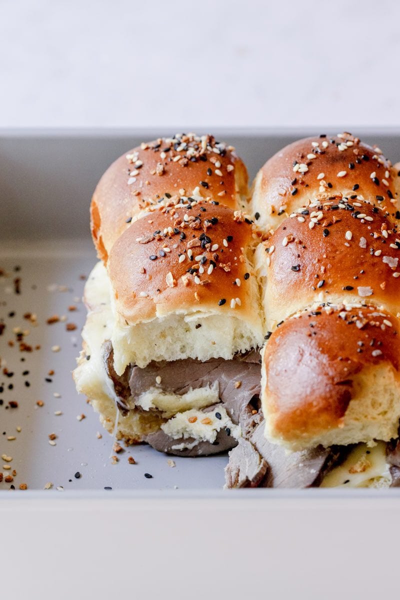 cooked roast beef sliders with one slider cut out from the corner