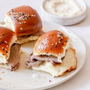 3 roast beef sliders on a white plate