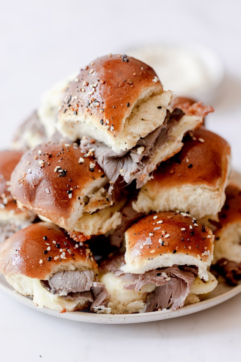 plate piled high with roast beef sliders on Hawaiian rolls