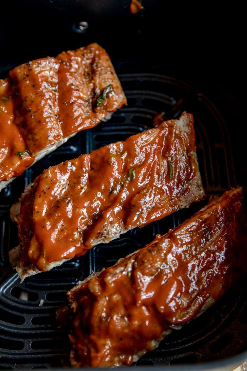 pork ribs in on a black sheet pan