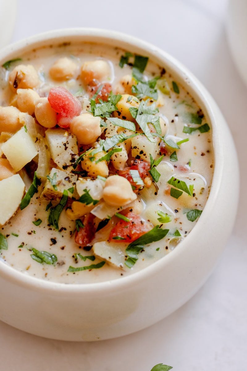 creamy italian chickpea soup served in a bowl topped with parsley