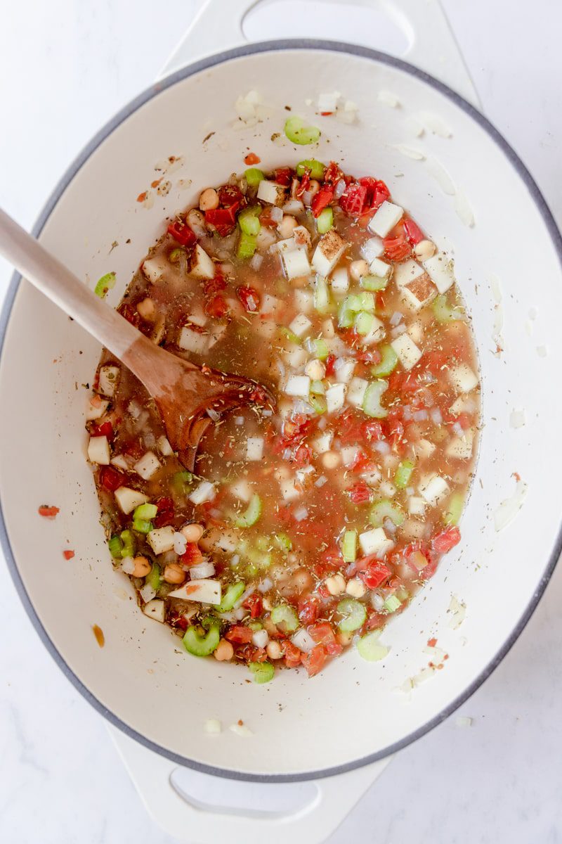 chicken stock added to cooked veggies for chickpea soup