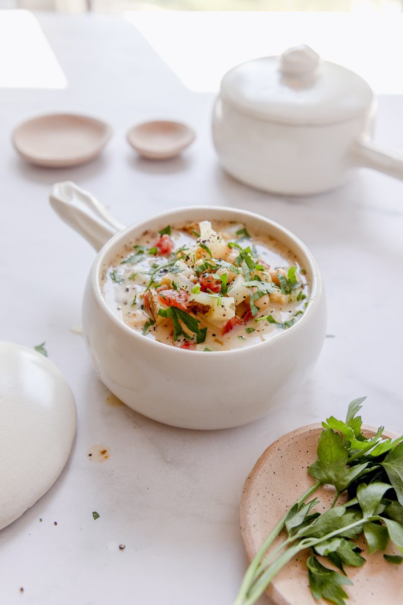 chickpea soup in a white bowl garnished with fresh parsley