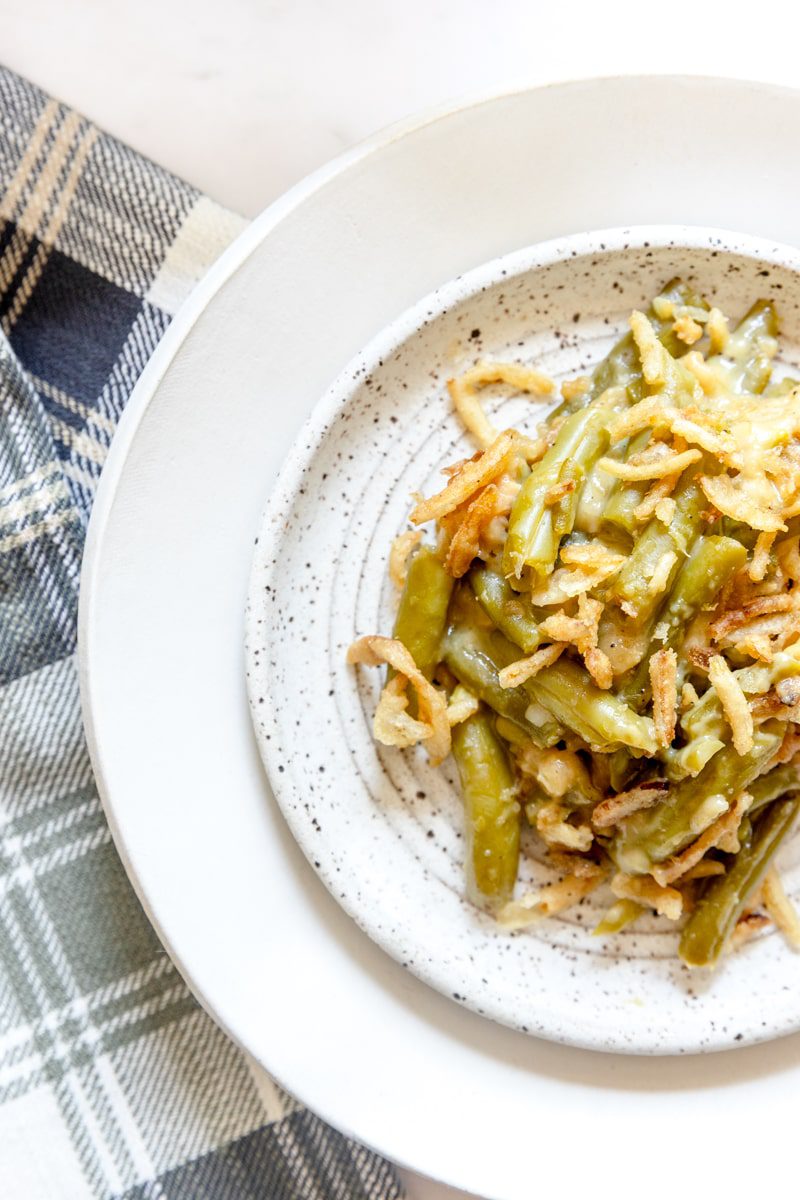 White plate of green bean casserole without mushroom soup