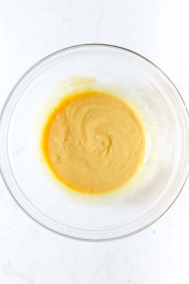 milk, condensed soup, and soy sauce whisked together in a glass bowl 