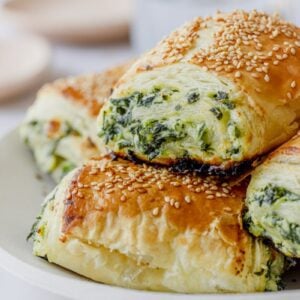 stack of spinach and ricotta rolls on a white plate