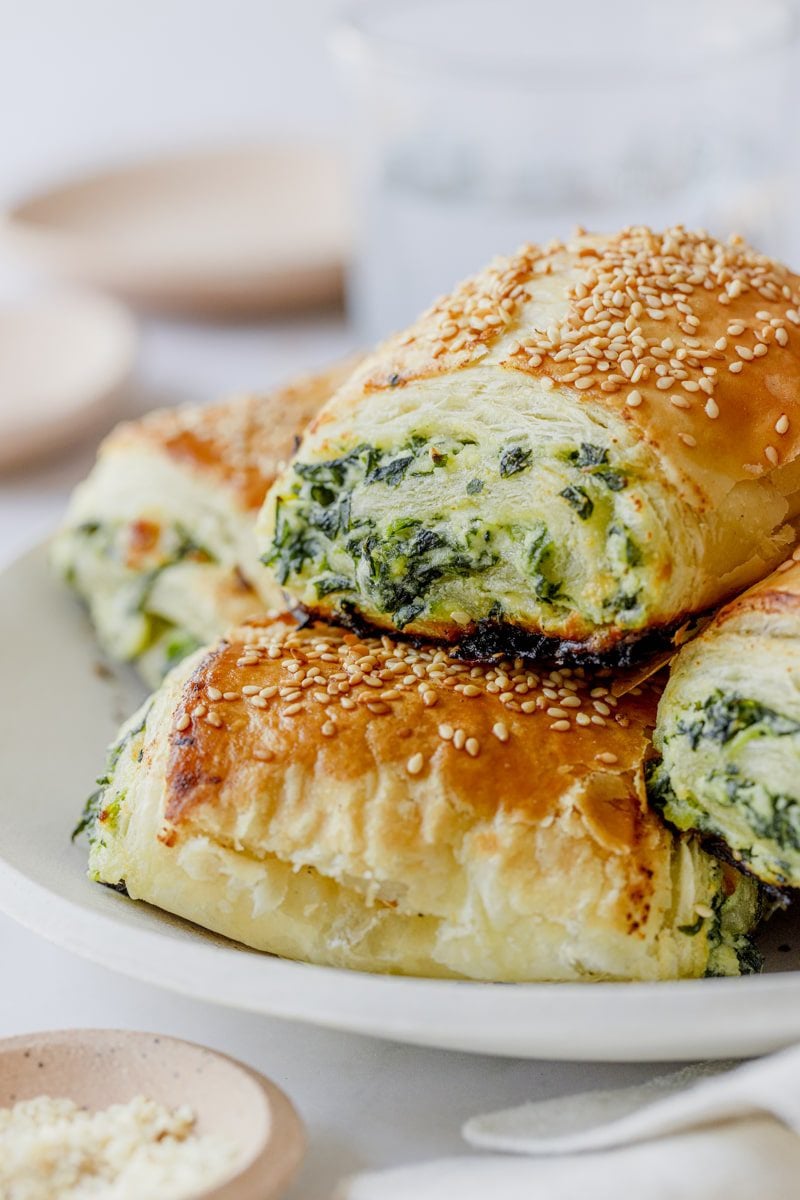 stack of spinach and ricotta rolls on a white plate