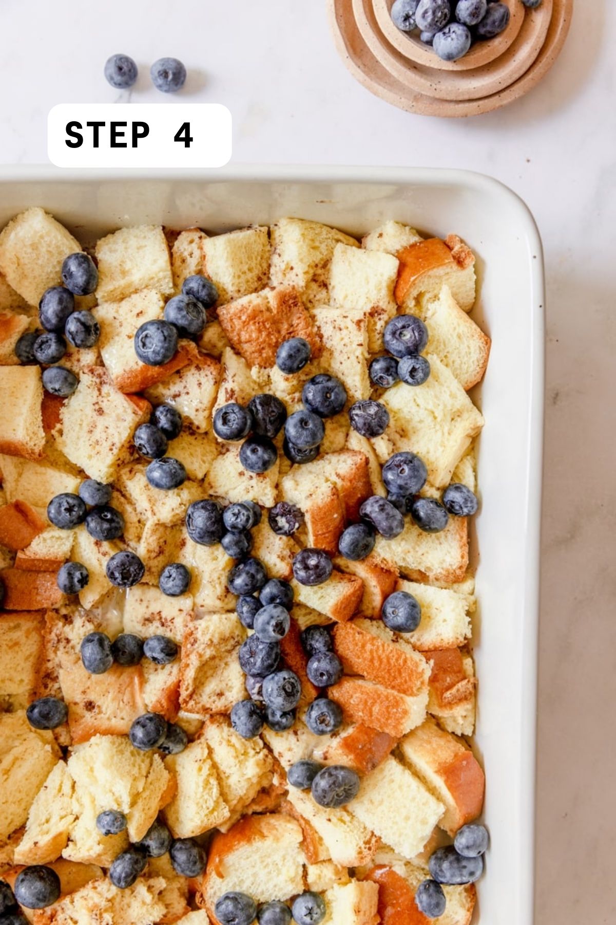 Unbaked casserole topped with blueberries. 