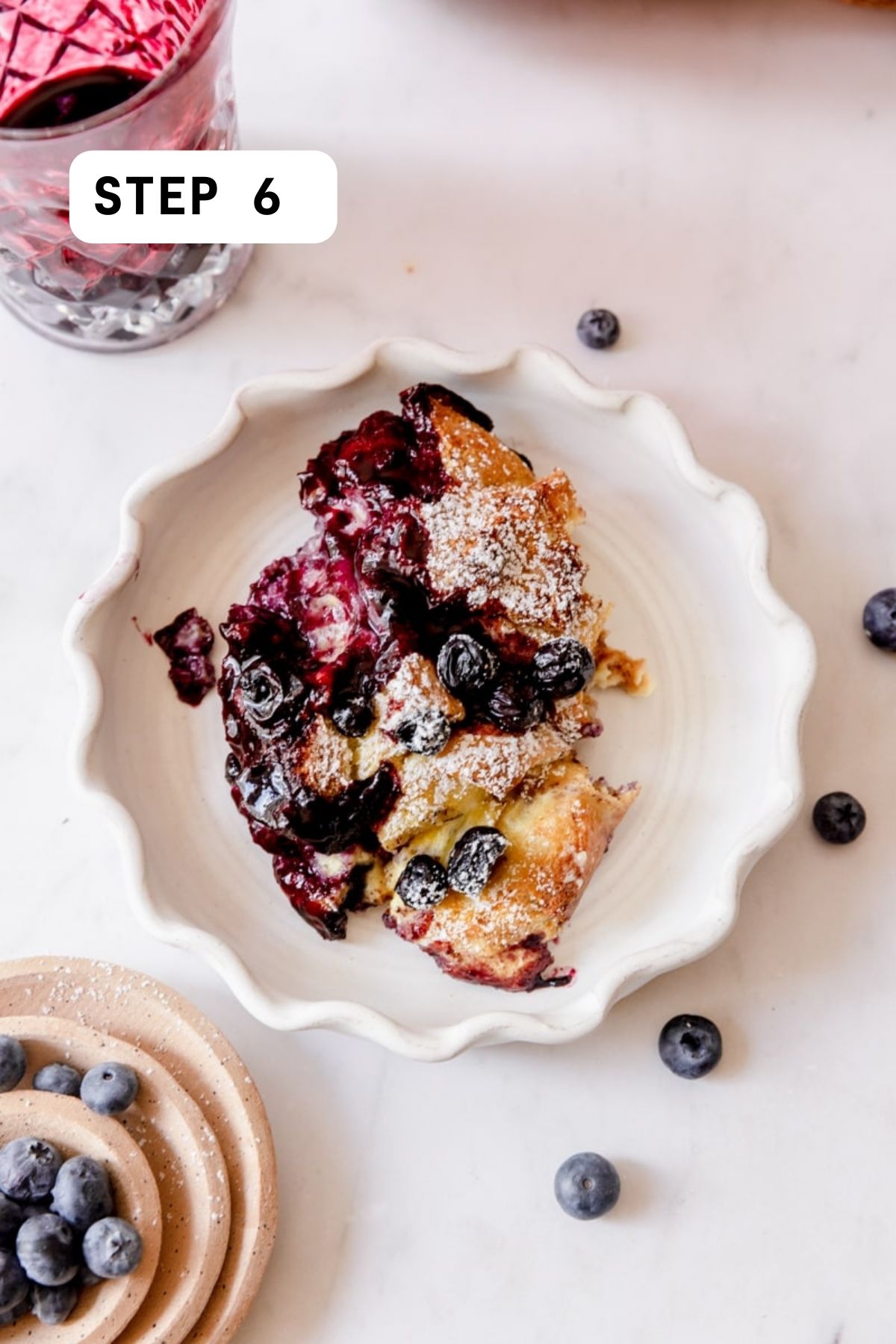 plated blueberry brioche French toast casserole on a scalloped plate. 