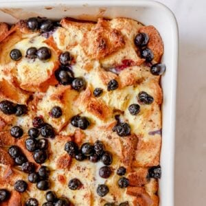 baked blueberry brioche French toast casserole topped with extra blueberries.
