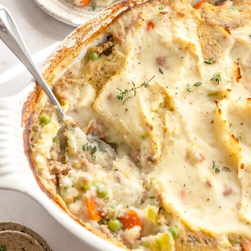 oval baking dish with ground turkey sheperd's pie with a spoon in it