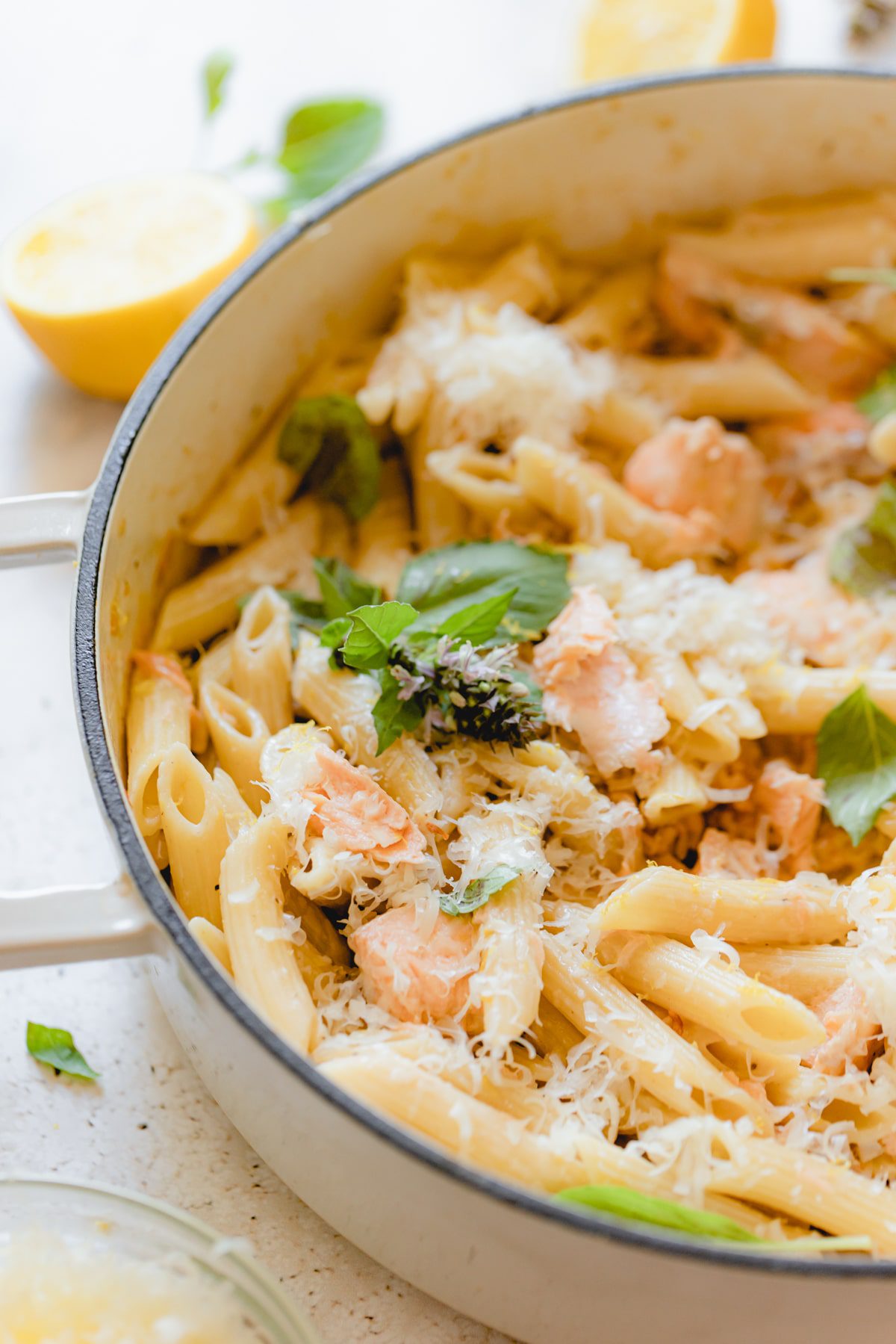 Skillet of pasta al salmone garnished with fresh basil.