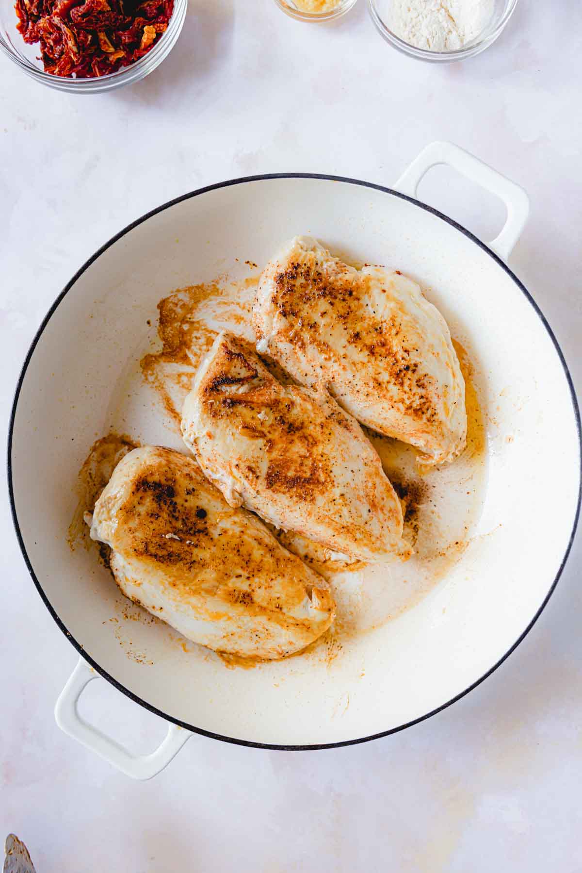 Searing chicken in a skillet. 