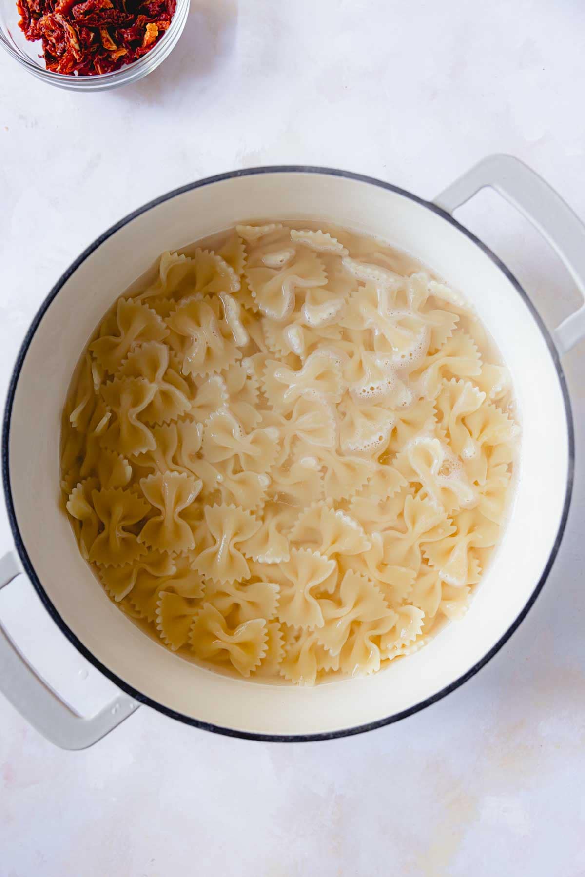 Bowtie pasta boiling in water in a large pot. 