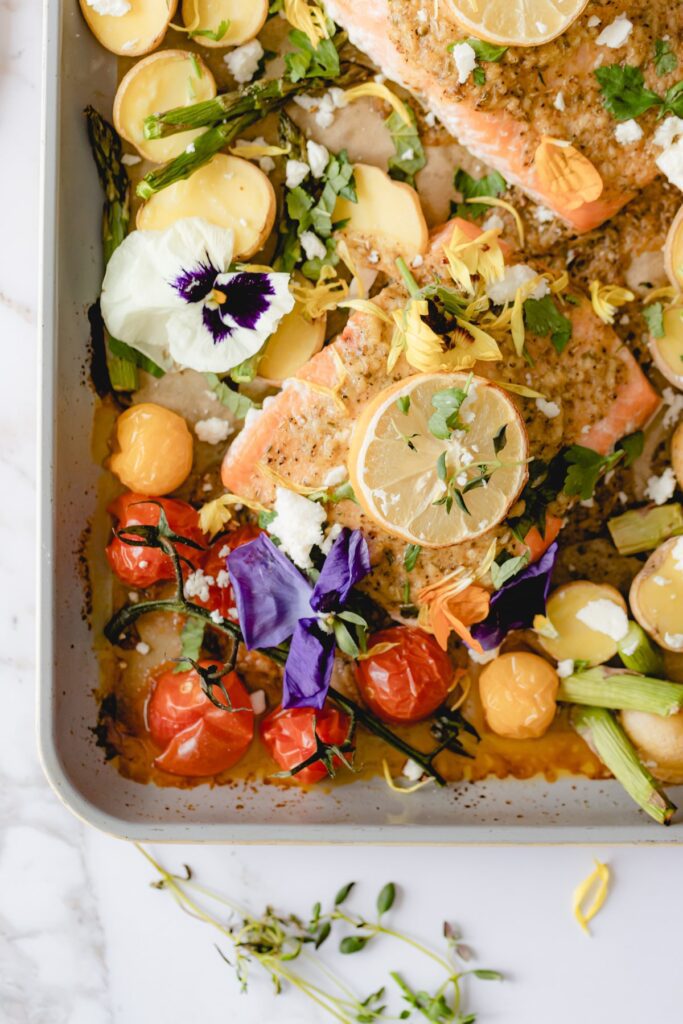Mediterranean salmon on sheet tray garnished with lemon.